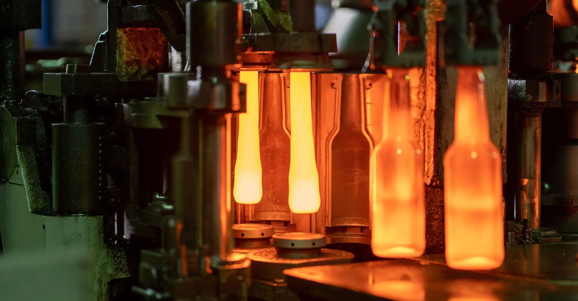 Glowing glass bottles leaving a forming machine in Xuzhou